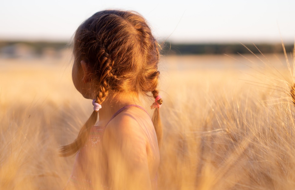 A baby girl in the grassland.